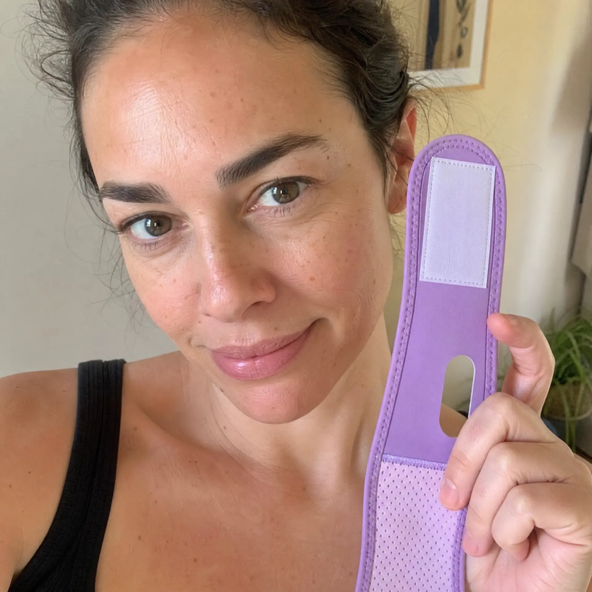 Noor holding her Lavender JawSnap strap